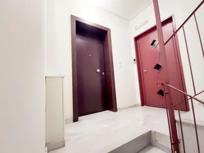 a hallway with a red door and a staircase at Apartment, Piraeus in Piraeus