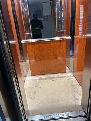 a man standing in front of a mirror in a elevator at Παιδων ΣΤΟΥΝΤΙΟ in Athens