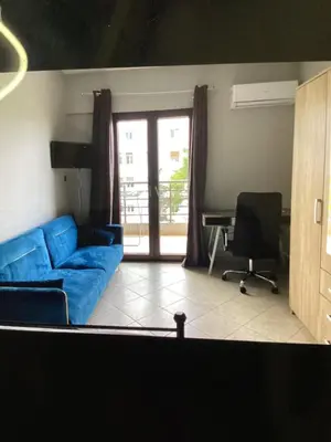 a living room with a blue couch and a desk at Παιδων ΣΤΟΥΝΤΙΟ in Athens