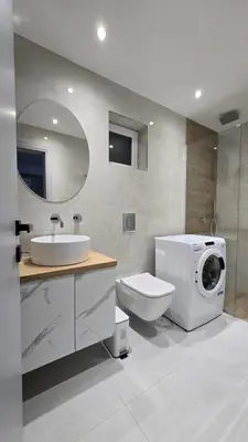 a bathroom with a washing machine next to a toilet at S&A apartments in Piraeus