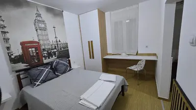 a bedroom with a bed and a picture of the city at S&A apartments in Piraeus