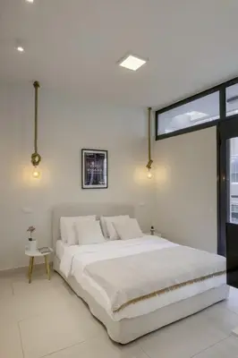 a white bedroom with a large bed and a window at Sci-Fi Themed Studio in Koukaki in Athens