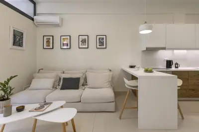 a white living room with a couch and a table at Sci-Fi Themed Studio in Koukaki in Athens