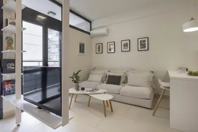 a living room with a white couch and a table at Sci-Fi Themed Studio in Koukaki in Athens