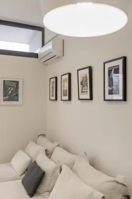 a living room with a white couch with pillows at Sci-Fi Themed Studio in Koukaki in Athens