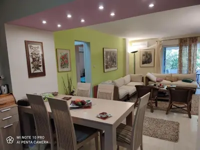 a kitchen and living room with a table and chairs at beautiful beach apartment in Kavouri in Athens