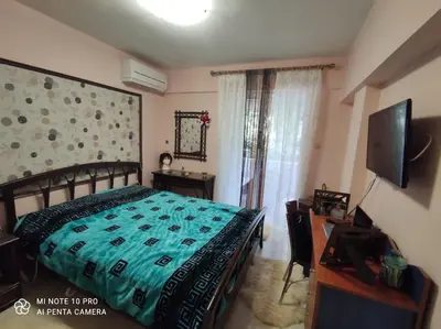 a bedroom with a bed and a television and a desk at beautiful beach apartment in Kavouri in Athens