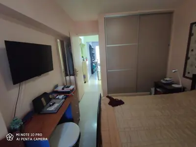 a room with a bed and a television on the wall at beautiful beach apartment in Kavouri in Athens