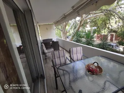 a table and chairs on a balcony with a turkey on it at beautiful beach apartment in Kavouri in Athens
