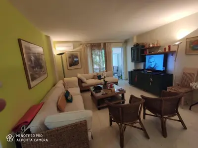 a living room with a couch and a tv at beautiful beach apartment in Kavouri in Athens