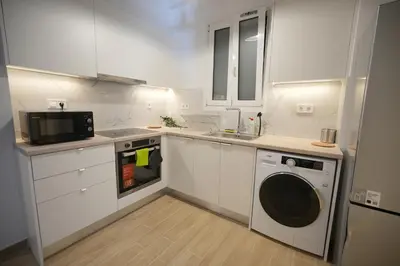 a kitchen with a washing machine and a microwave at Central 1 BDRM apartment, in Pangrati in Athens