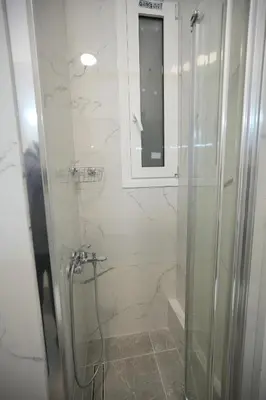 a bathroom with a shower with a glass door at Central 1 BDRM apartment, in Pangrati in Athens