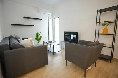 a living room with two chairs and a television at Central 1 BDRM apartment, in Pangrati in Athens