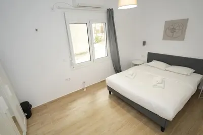 a bedroom with a white bed and a window at Central 1 BDRM apartment, in Pangrati in Athens