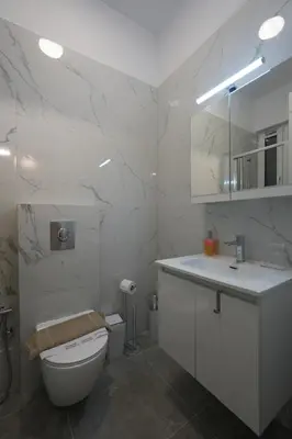a white bathroom with a toilet and a sink at Central 1 BDRM apartment, in Pangrati in Athens