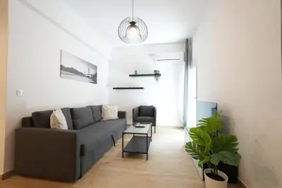 a living room with a gray couch and a chair at Central 1 BDRM apartment, in Pangrati in Athens