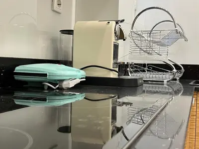a kitchen counter with a hair dryer and a drying rack at Townheart House in Athens in Athens