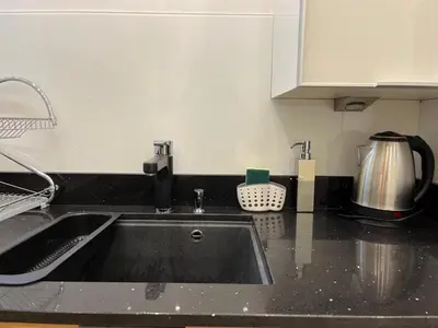 a kitchen counter with a sink and a coffee pot at Townheart House in Athens in Athens