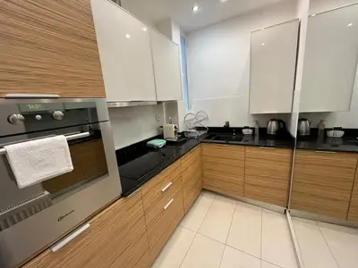 a kitchen with white cabinets and black appliances at Townheart House in Athens in Athens