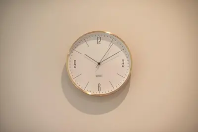 a clock is hanging on a white wall at Top Ten Studio in Athens