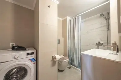 a bathroom with a washing machine and a sink at Top Ten Studio in Athens