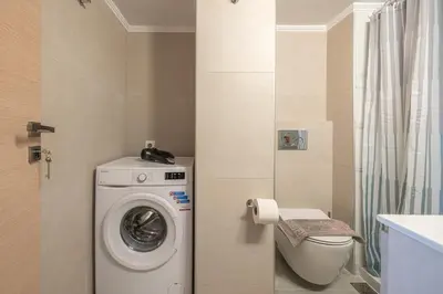 a bathroom with a washing machine and a toilet at Top Ten Studio in Athens