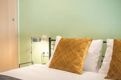 a bedroom with a bed with white sheets and pillows at Top Ten Studio in Athens