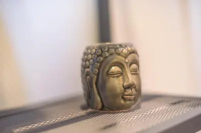 a gold buddha figurine sitting on a shelf at Top Ten Studio in Athens