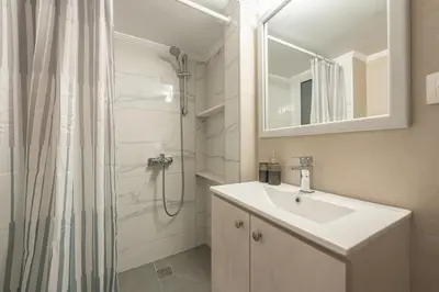 a bathroom with a sink and a shower with a shower curtain at Top Ten Studio in Athens