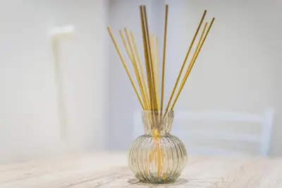 a glass vase with sticks in it on a table at Home near Flisvos Marina in Athens