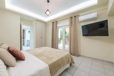 a bedroom with a bed and a flat screen tv at Home near Flisvos Marina in Athens