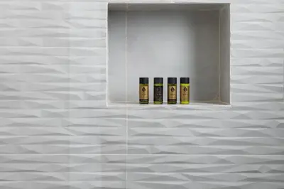 three bottles of essential oils on a shelf on a wall at Glyfada Luxury Suite by First Class Properties in Athens