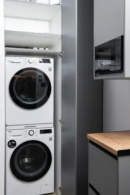 a kitchen with a washing machine and a microwave at Glyfada Luxury Suite by First Class Properties in Athens