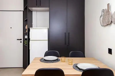 a dining room with a table with chairs and a refrigerator at Defner Tzo's Modern Apartment in Athens