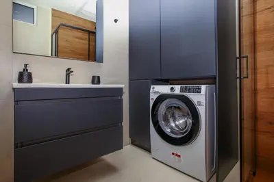 a bathroom with a washing machine and a sink at Defner Tzo's Modern Apartment in Athens