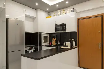 a kitchen with a black counter top and a refrigerator at Athenian Escape - Located near the heart of Athens in Athens