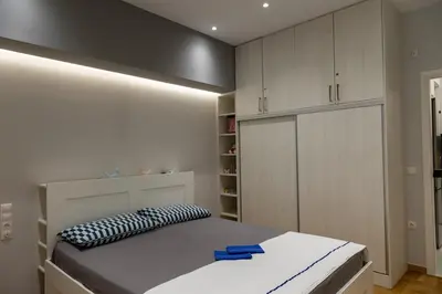 a bedroom with a bed with a black and white pillow at Athenian Escape - Located near the heart of Athens in Athens