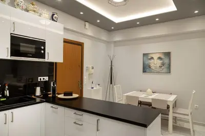 a kitchen with a black counter top and a table at Athenian Escape - Located near the heart of Athens in Athens