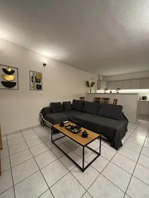 a living room with a couch and a table at Cozy apartment by Athens in Athens