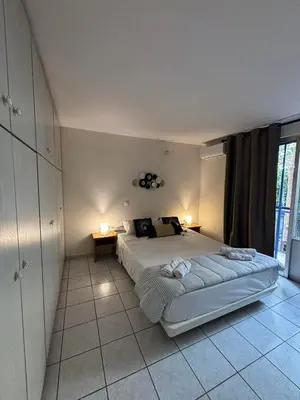 a bedroom with a large bed with two lamps on it at Cozy apartment by Athens in Athens