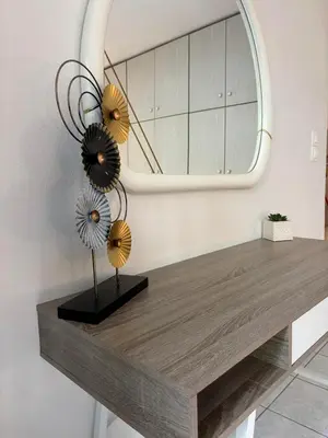 a table with a mirror and flowers on it at Cozy apartment by Athens in Athens