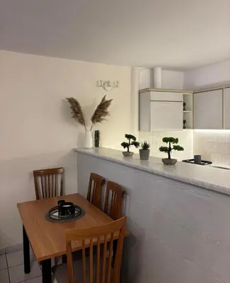 a kitchen with a table and chairs and a counter at Cozy apartment by Athens in Athens