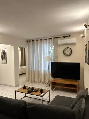 a living room with a couch and a flat screen tv at Cozy apartment by Athens in Athens