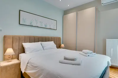 a bedroom with a large white bed with two towels on it at AMAZING PENTHOUSE FOR SIX person in Athens