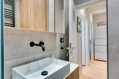 a bathroom with a white sink and a hallway at AMAZING PENTHOUSE FOR SIX person in Athens