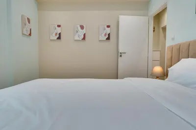 a white bed in a bedroom with pictures on the wall at AMAZING PENTHOUSE FOR SIX person in Athens