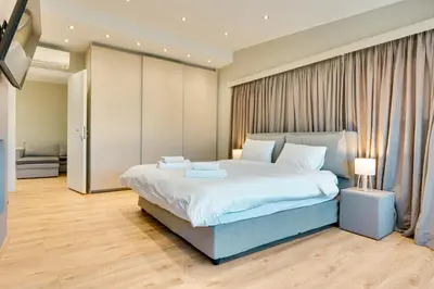 a bedroom with a large bed and a television at AMAZING PENTHOUSE FOR SIX person in Athens