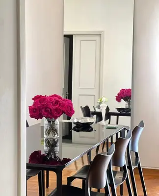 a dining room with chairs and a table with red roses at Central Athenian Maison, with Acropolis Views in Athens