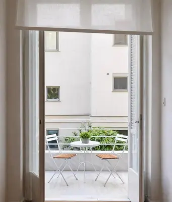 a view of a table and chairs from a window at Central Athenian Maison, with Acropolis Views in Athens