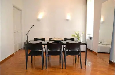 a dining room with a table and black chairs at Central Athenian Maison, with Acropolis Views in Athens